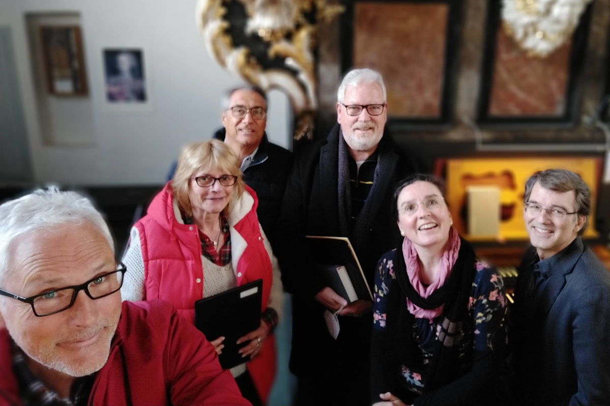 Palmsonntag in der Kreuzbergkirche: zwei Sängerinnen, drei Sänger und der Chorleiter vor der Orgel